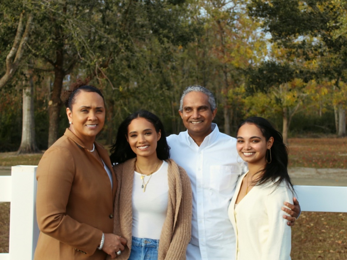 A family of five standing together outdoors