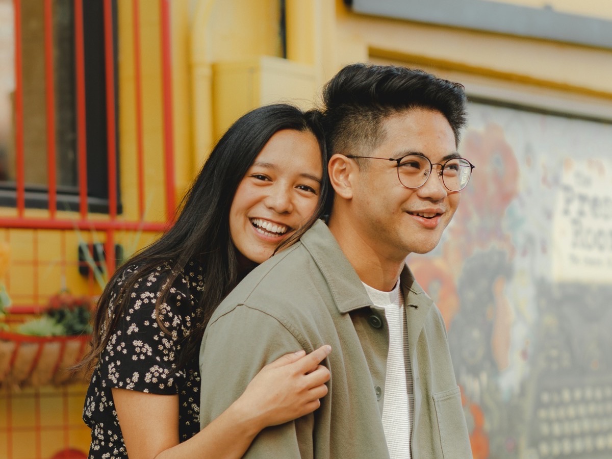 Una pareja joven frente a un muro pintado